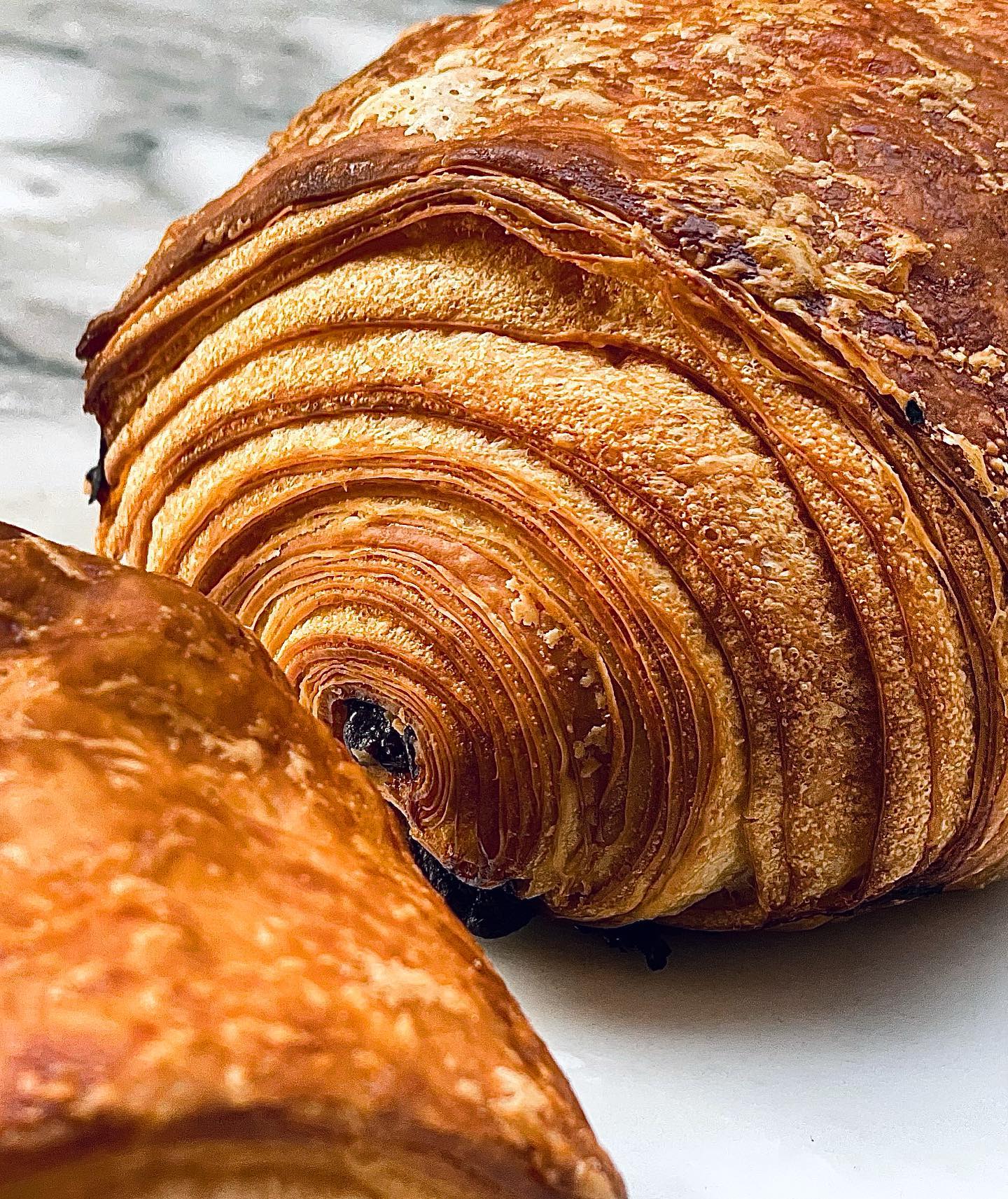 Gros plan sur le feuilletage doré des viennoiseries Amandine